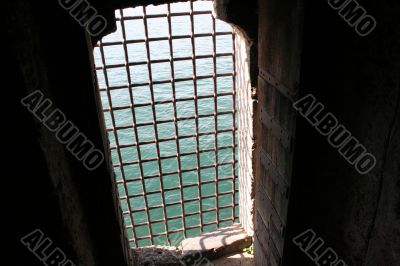 Grilled castle window overlooking the sea