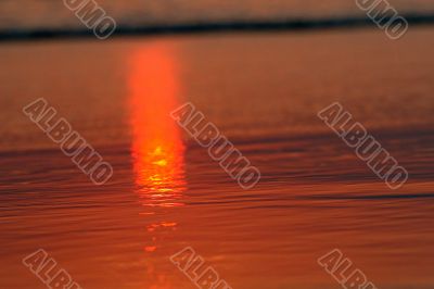 red rays of sunlight on the sand
