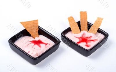 Two creamy desserts, with cracker on black plate
