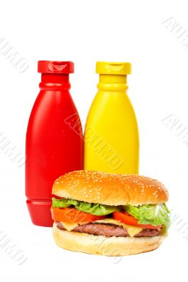 Burger with mustard and ketchup bottles