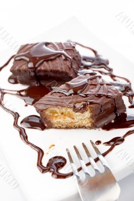 Two chocolate cakes with syrup and the fork