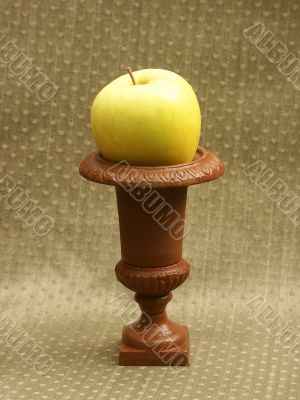 yellow green apple on small pedestal yellow green apple on small pedestal