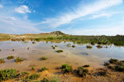 Hill over the blue sky and the lake