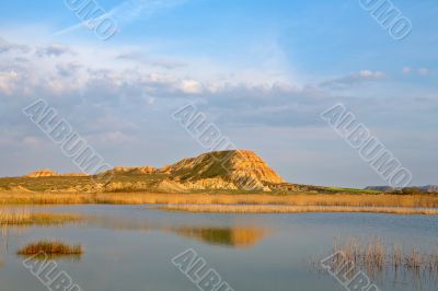 Hill over the blue sky and the lake