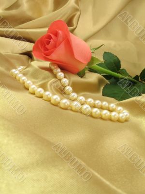 Pink rose and pearls on gold satin