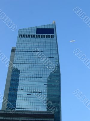 Corporate building with a plane on the blue sky