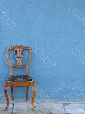 wooden chair alone with blue background
