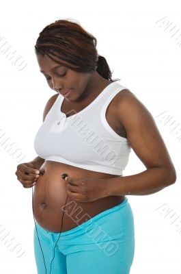 attractive pregnant woman putting the baby music