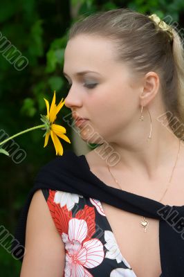 The young girl with a yellow flower close up