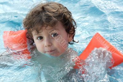 adorable boy learning to swim