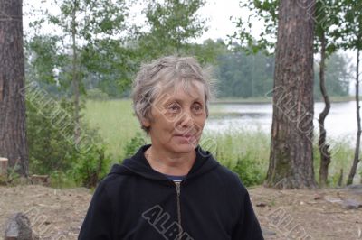 Elderly woman in forest glade