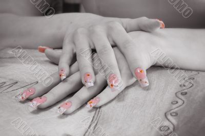 two hands with painted and decorated nails