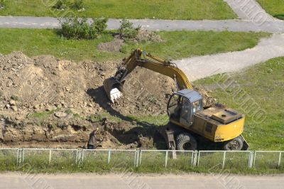 Excavator and man are digging together