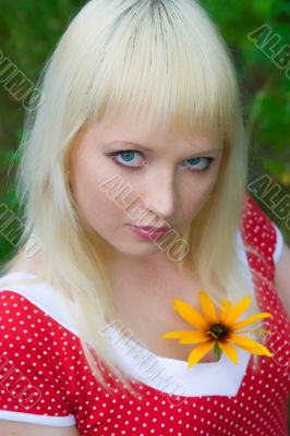 The young girl with a yellow flower close up