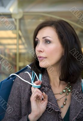 The young beautiful woman with purchases in stor