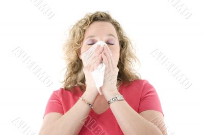 Young blond girl sneezing in the handkerchief