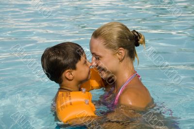 son and mom swim and play in the pool