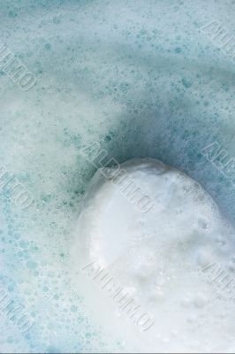 White soap in foam on a blue background