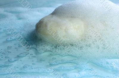 White soap in foam on a blue background