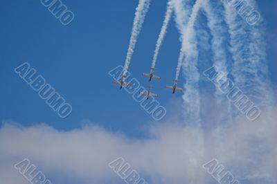 four planes in formation with vapour trails