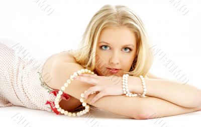 laying blond in pink dress with pearls