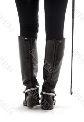 beautiful legs in black leather horseman boots with riding-crop