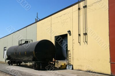 Black tank car, on railroad siding