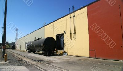 Black tank car, on railroad siding