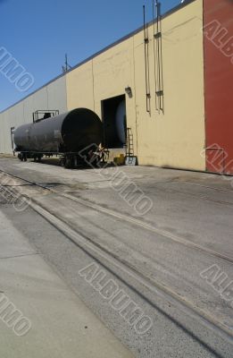 Black tank car, on railroad siding