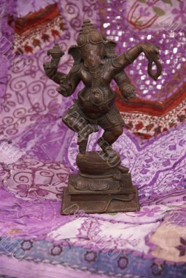 Bronze Ganesha dancing, on purple