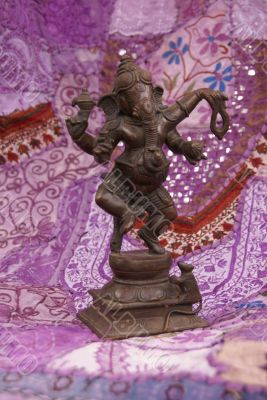 Bronze Ganesha dancing, on purple