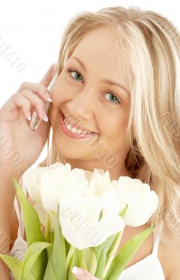 cheerful blond with white tulips and phone cheerful blond with white tulips and phone