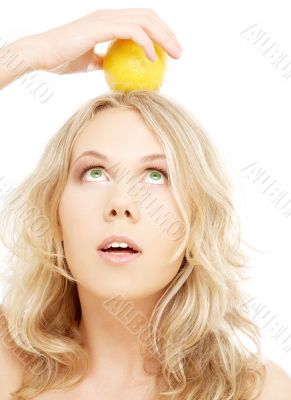 healthy blond holding lemon on her head healthy blond holding lemon on her head