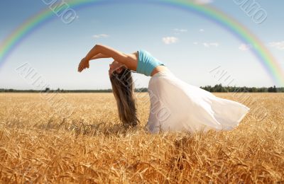 stretching woman in the meadow with rainbow