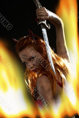 dark devil girl with a knife in fire