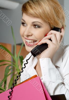 office lady with folders making a phone call