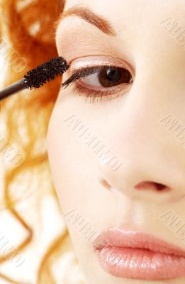 lovely redhead applying black mascara