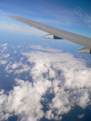 Aeroplane wing over clouds.