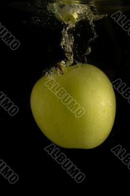 Green apple fallen into the water