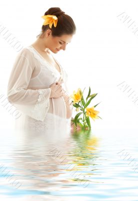 pregnant woman with yellow lily in water