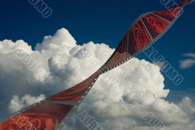 Film with roses on a background of the cloudy sky