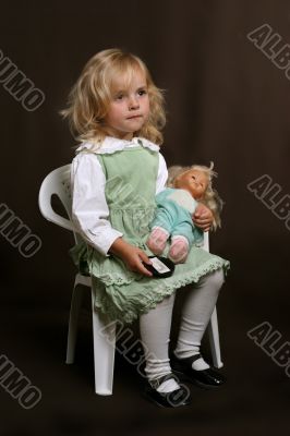 cute little girl in green dress with doll