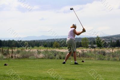 Lady golfer hitting ball from tee