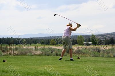 Lady golfer hitting ball from tee