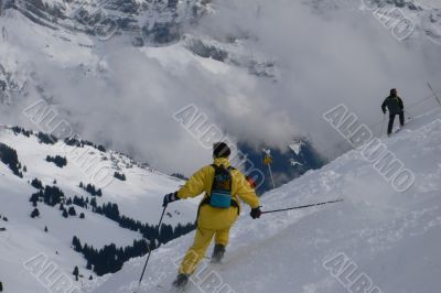 Yellow skier traversing steep slope