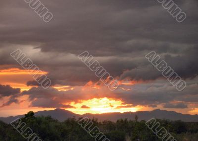  Sun setting and showing thru Rain clouds