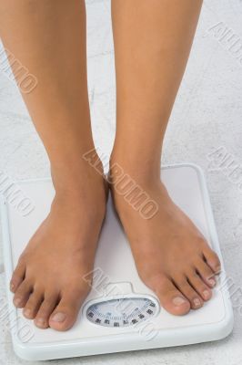 Two female feet on a bathroom scale