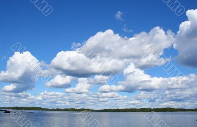 blue sky with curly white clouds above the lake