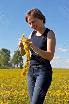 woman twining a dandelion wreath