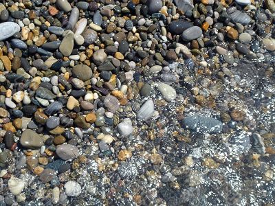 Wet brilliant pebble and sea wave